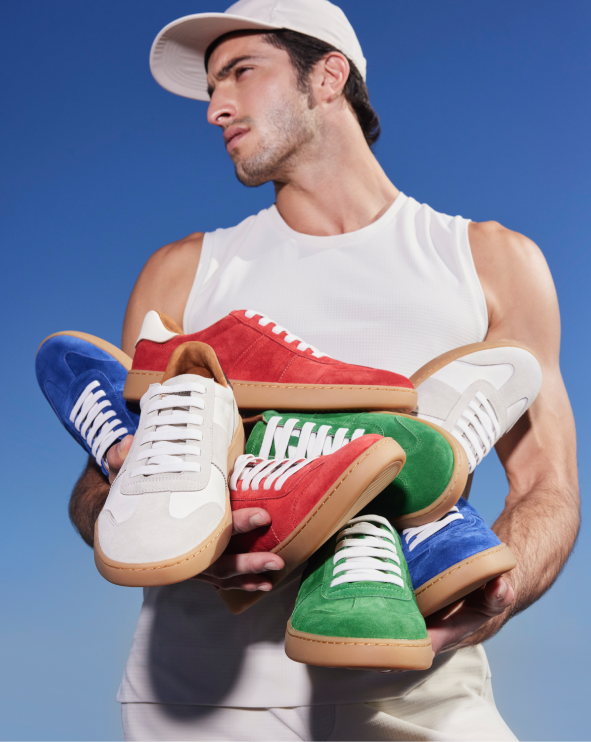 man holding several sneakers in different colors