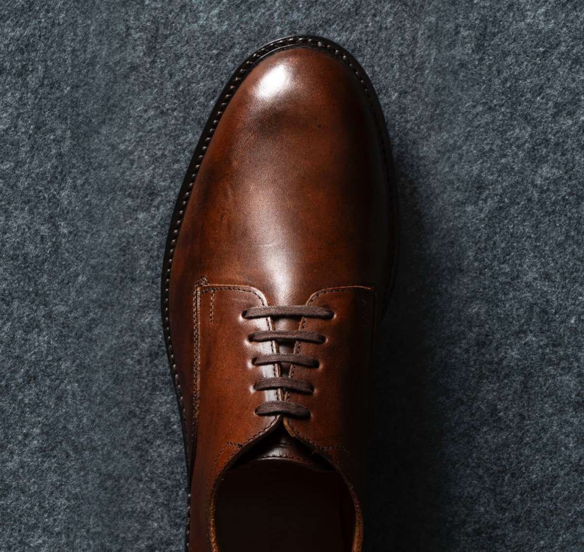 A top view of a men’s derby shoe in brown leather. Vue du dessus d'une chaussure derby pour homme en cuir marron.
