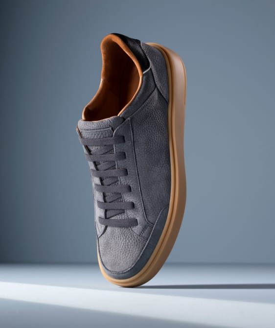 Men’s gray textured leather sneaker with tan rubber sole and brown leather lining