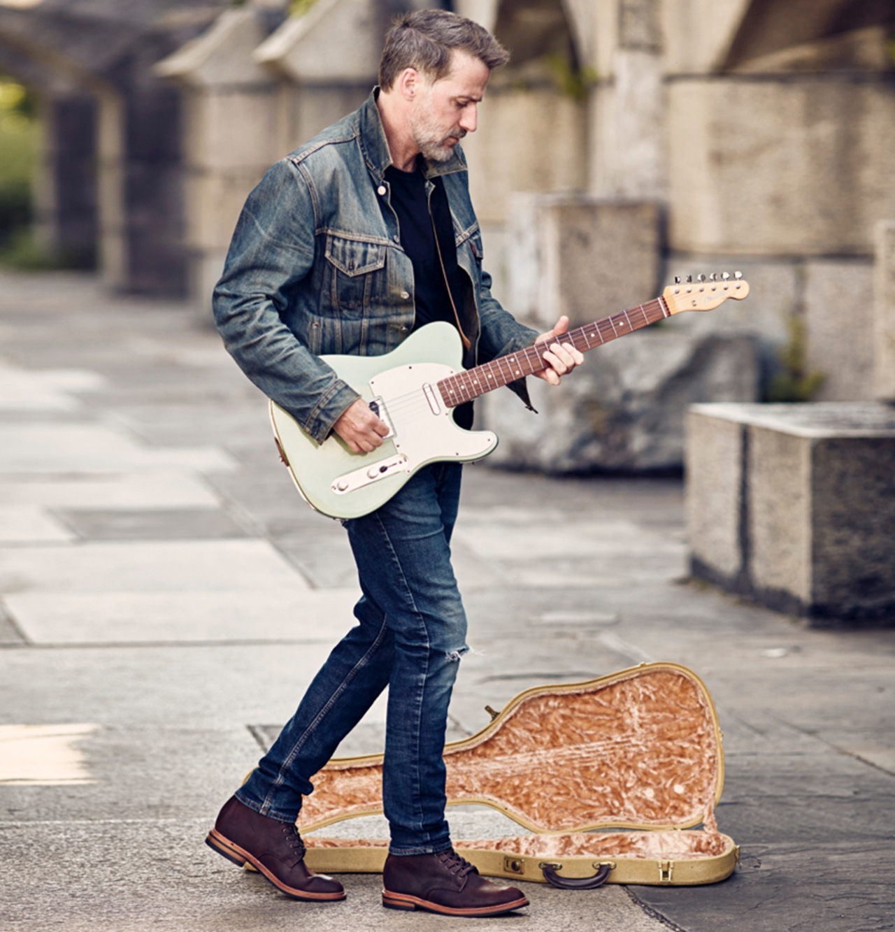 Man playing guitar in Higgins Mill boots by Allen Edmonds